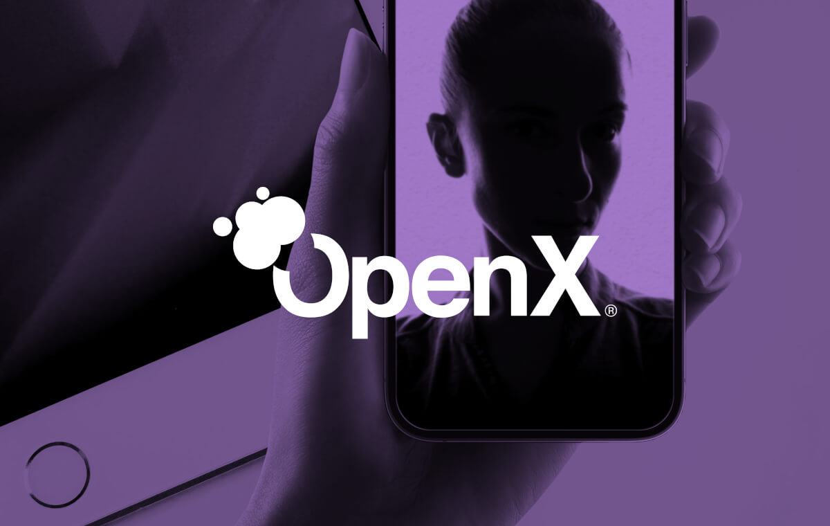 A woman is holding up a phone with the word openx on it.